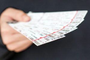 A person holding up tickets to play in an event.