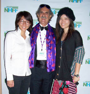 Three film festival attendees in front of a photo wall