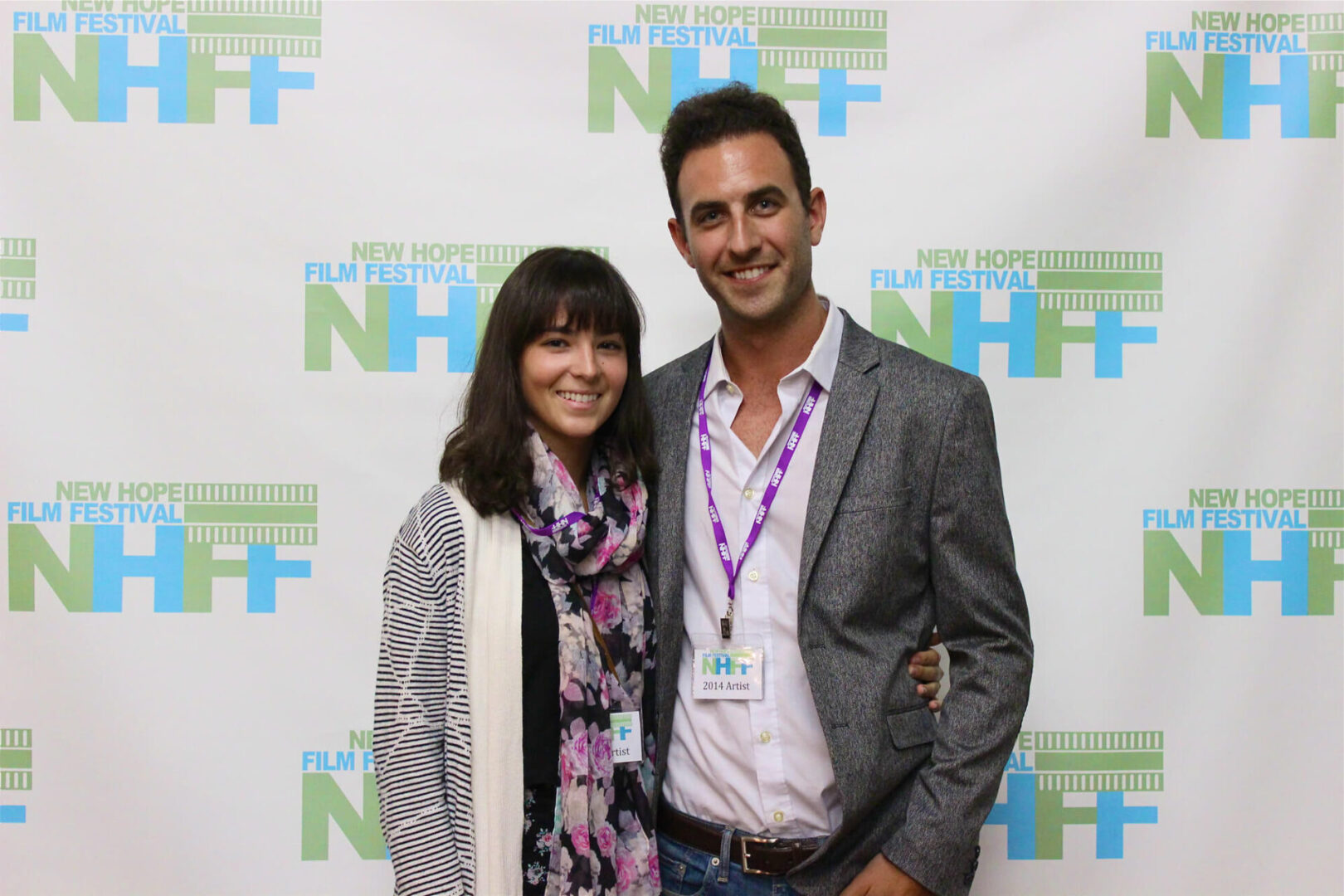 Two film festival attendees in front of a photo wall